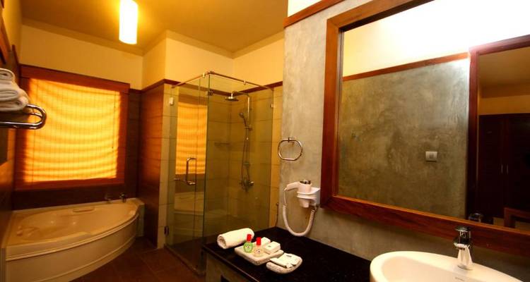 Moderne hotelbadkamer met glazen douche en marmeren aanrecht.