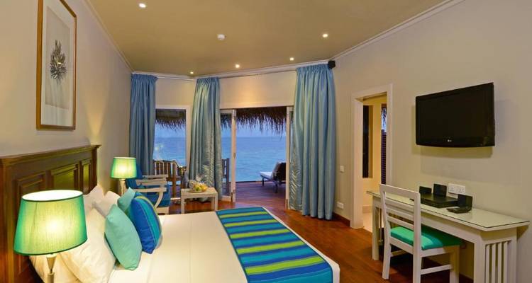 Hotelkamer met uitzicht op water, gedecoreerd in blauwe en groene tinten.