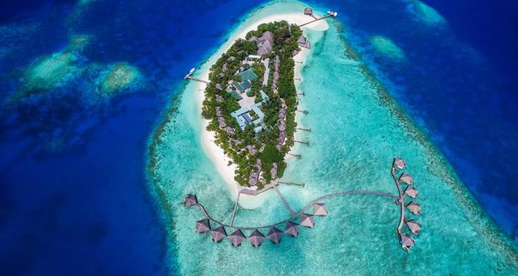 Luchtfoto van een tropisch eiland met helder blauw water en strand.