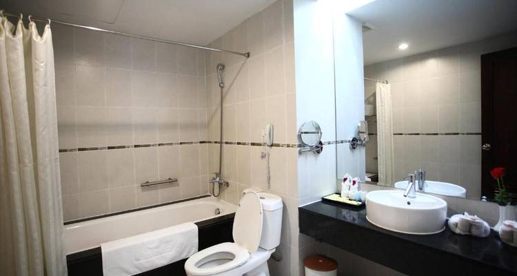 Eenvoudige hotelbadkamer met toilet en wastafel.