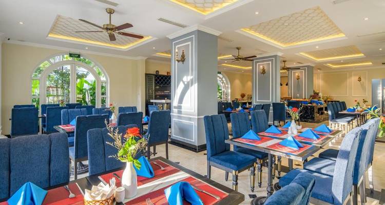 Salle à manger élégante avec des décorations colorées et des tables bien dressées.