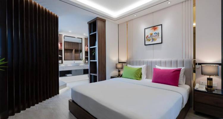 Chambre d'hôtel contemporaine avec un grand lit, un coin salon et un éclairage d'ambiance.