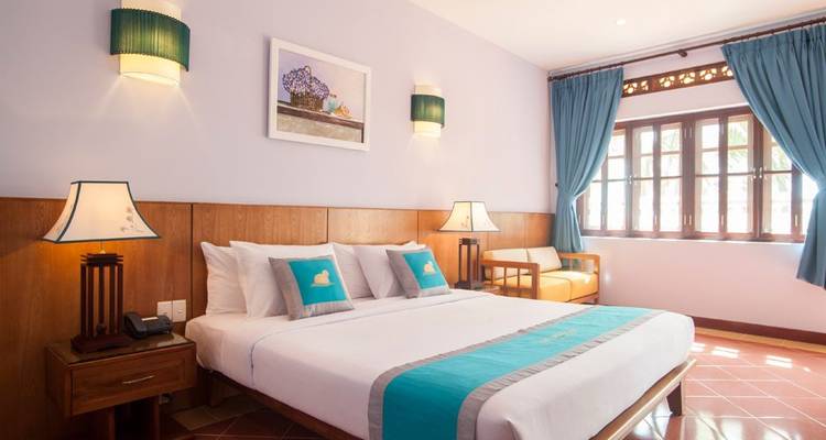 Scène d'un pêcheur jetant son filet dans une rivière au lever du soleil.