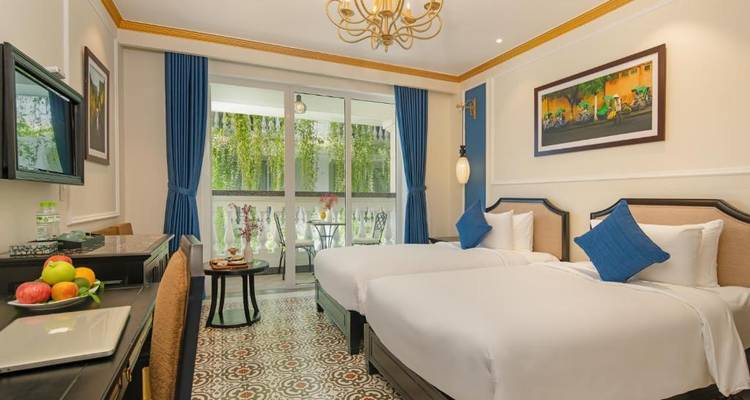 Hotelkamer met twee eenpersoonsbedden, blauwe gordijnen en uitzicht.