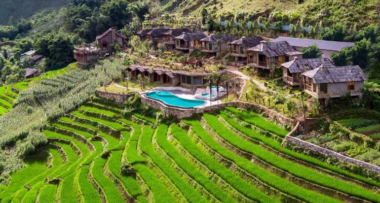 Terrasvormige rijstvelden met resortgebouwen en een zwembad