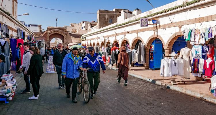 Rue commerçante avec des gens qui font du shopping et des bâtiments traditionnels
