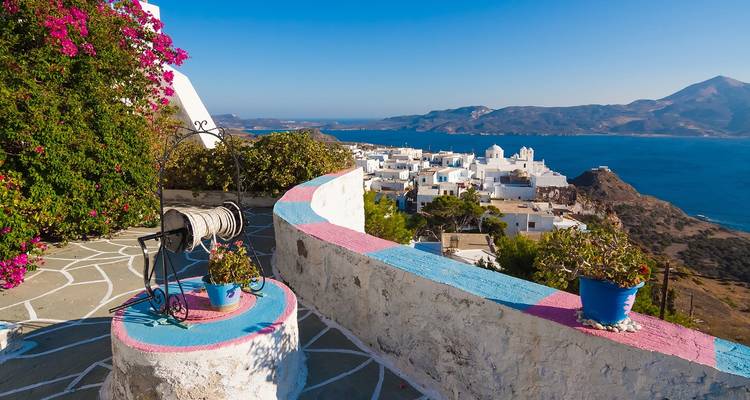 Een schilderachtig uitzicht vanaf een terras met kleurrijke bloemen uitkijkend over de zee.