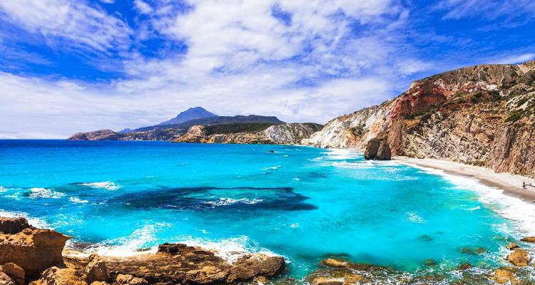 Een ongerept strand met turquoise water en dramatische kliffen.