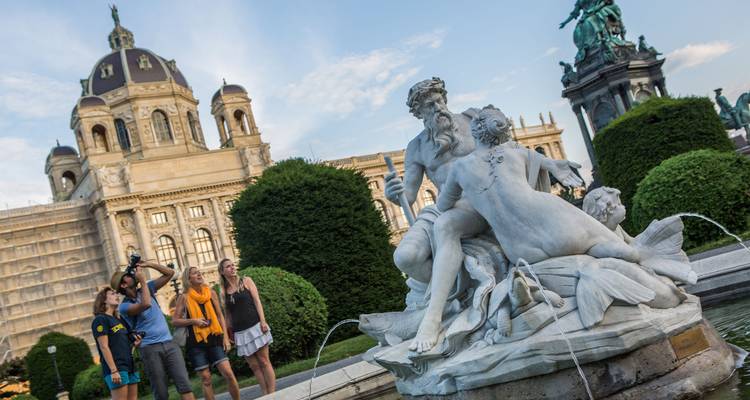 Group of travellers photograph and admire a marble fountain outside Vienna's Kunsthistorisches Museum.