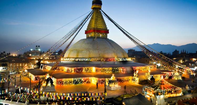 Stupa de Boudhanath illuminé au crépuscule avec des drapeaux de prière.