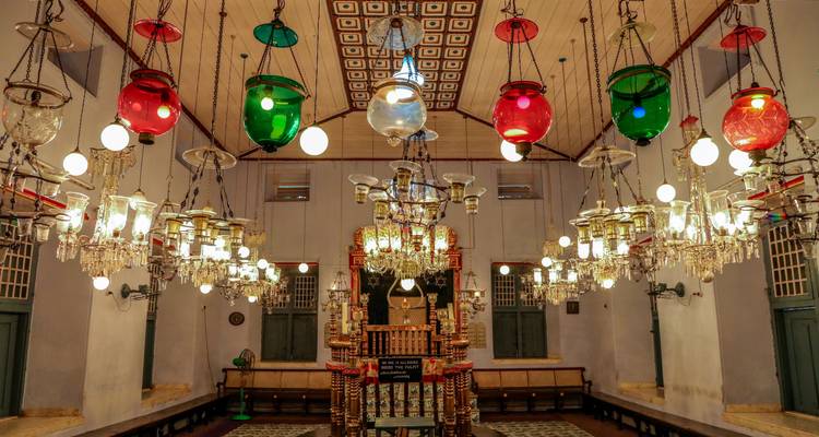Interior de una sinagoga con iluminación ornamentada.