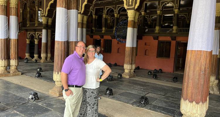 Pareja dentro de un edificio histórico con pilares decorativos.