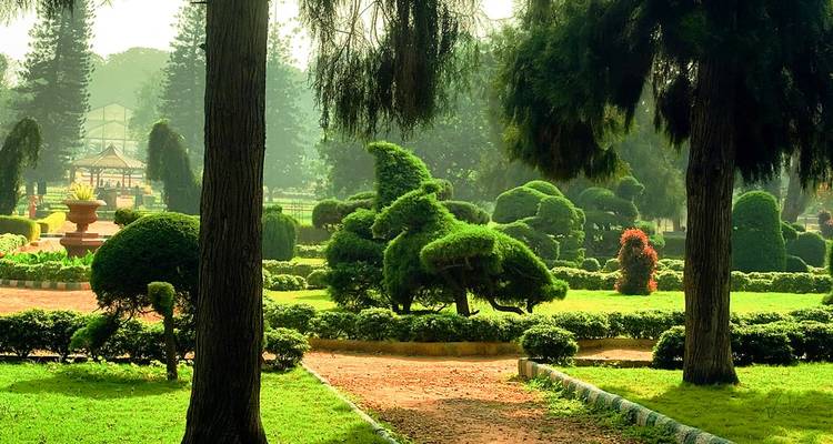 Jardin botanique bien entretenu avec topiaires et un sentier.