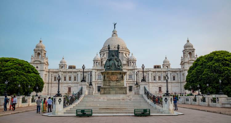 Victoria Memorial met een standbeeld ervoor omgeven door groen.
