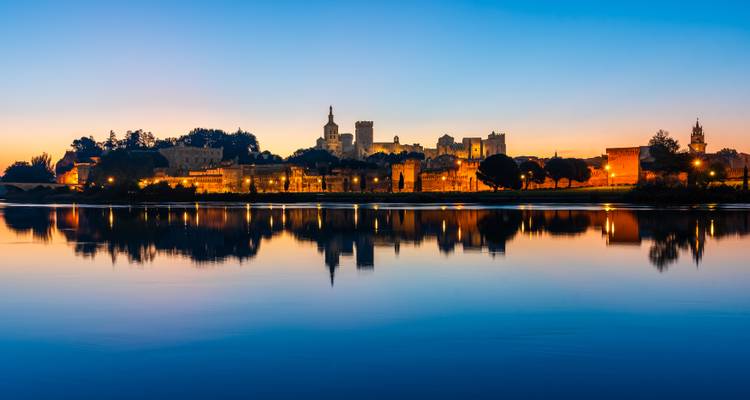 Silhouette du soir d'Avignon et du Palais des Papes se reflétant parfaitement dans les eaux calmes du Rhône