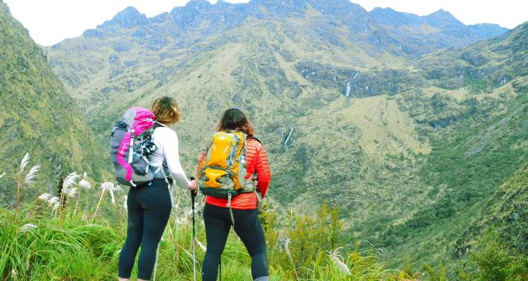 Twee wandelaars observeren een berglandschap.