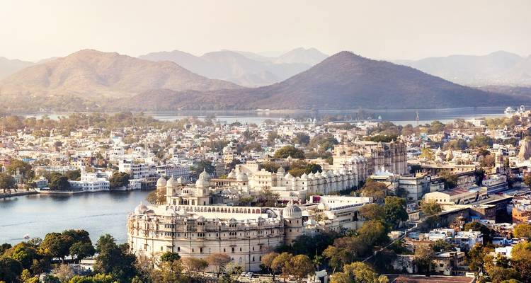 Luftaufnahme von Udaipur mit einem großen Palastkomplex nahe einem See.