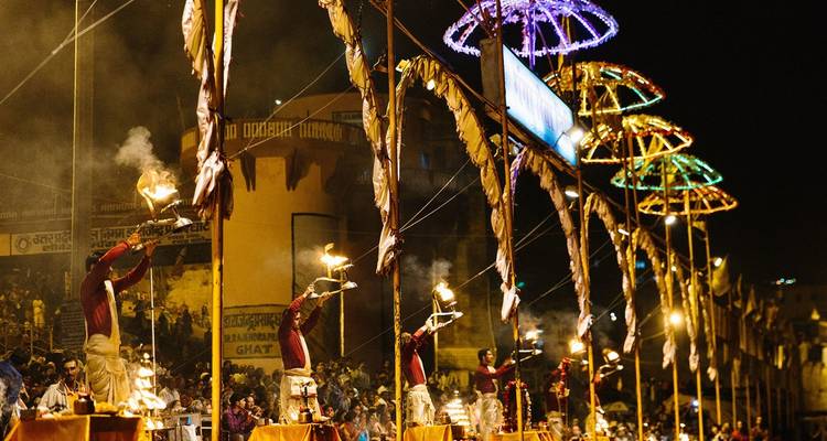 Nächtliche Flusszeremonie mit Menschen, die Feueropfergaben halten.
