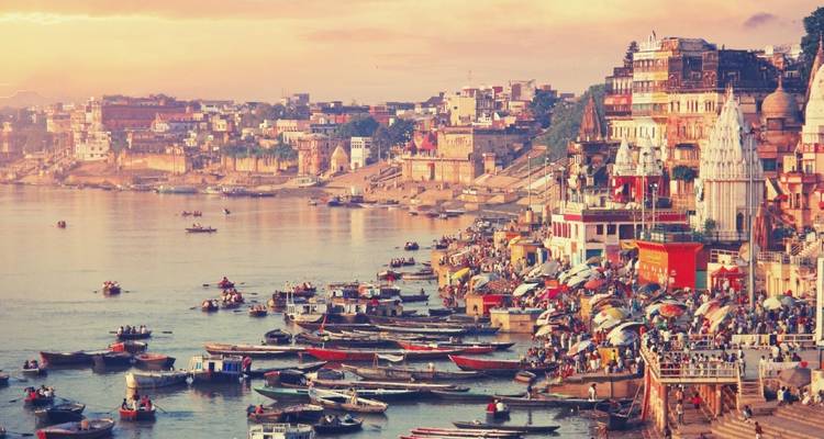 Blick auf die Ghats von Varanasi mit Booten auf dem Fluss.