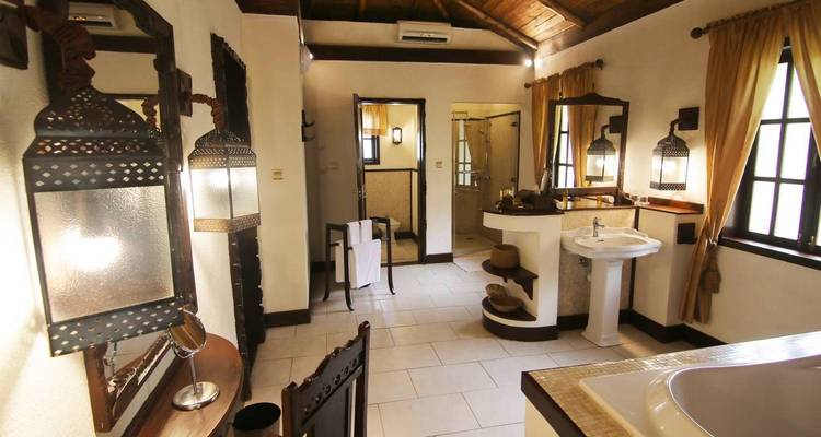 Elegant bathroom interior with decorative lamps and a bathtub.