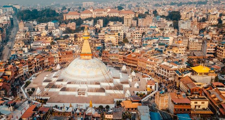 Aerial view of a large stupa in a dense urban area.