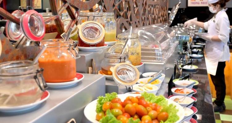 Buffet avec salades fraîches, fruits et condiments.