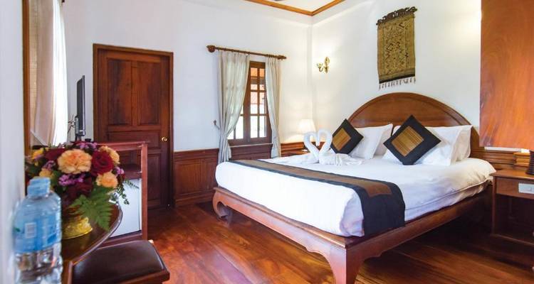 Chambre traditionnelle avec un grand lit et des accents en bois.