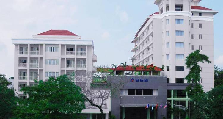 Bâtiment d'hôtel moderne avec des palmiers au premier plan.