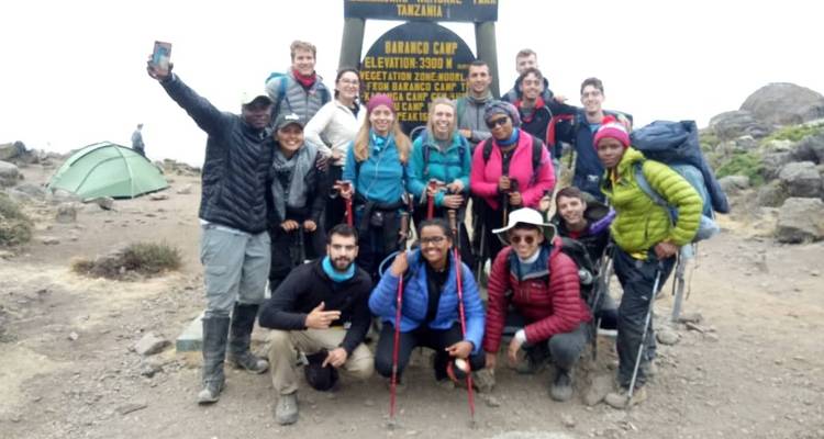 Eine Gruppe von Wanderern, die an einem Campingplatz mit einem Höhenschild posieren.