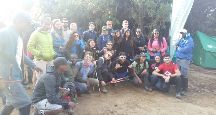 Eine große Gruppe von Menschen, die an einem Campingplatz für ein Foto posieren.