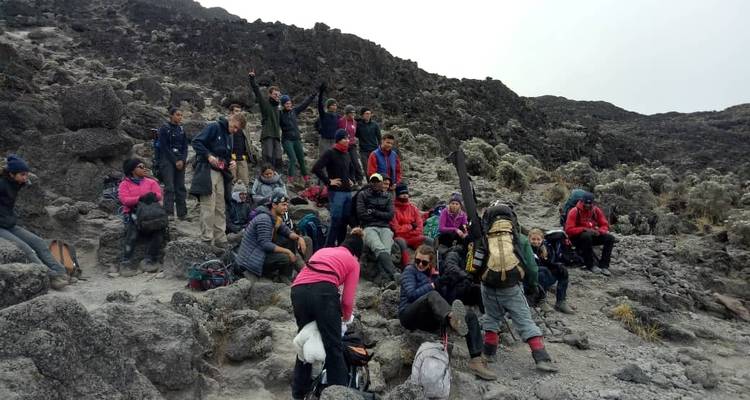 Hikers taking a break on a rocky mountain surface.