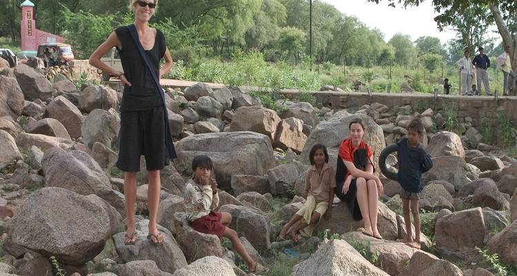 Toeristen die op grote rotsen zitten in een landelijke omgeving.