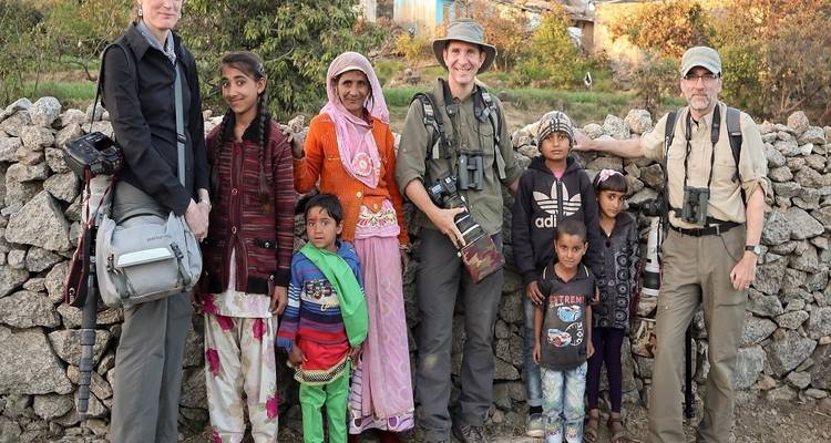 Reizigers die poseren met lokale dorpelingen in een landelijk gebied.
