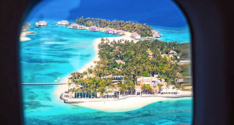 Aerial view of a tropical island with clear blue waters.