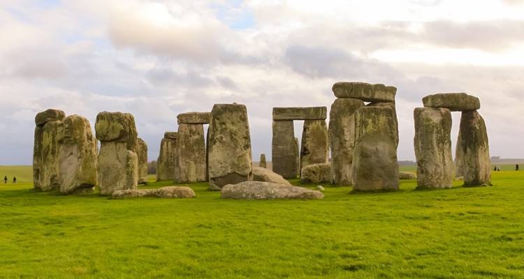 Stonehenge se alza prominentemente en un campo llano y cubierto de hierba.