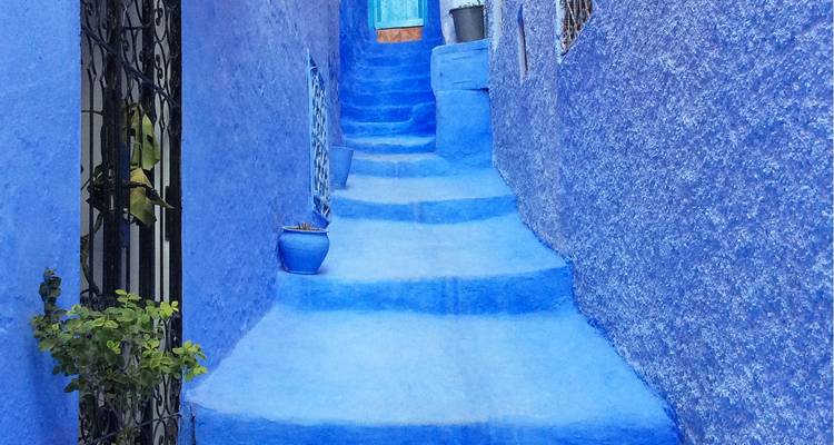 Stone steps leading through blue buildings in Chefchaouen.