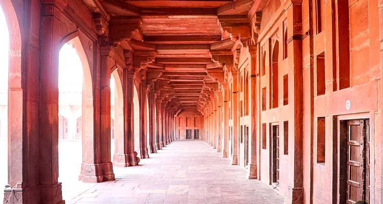 Zuilengalerij met rode zandstenen bogen.