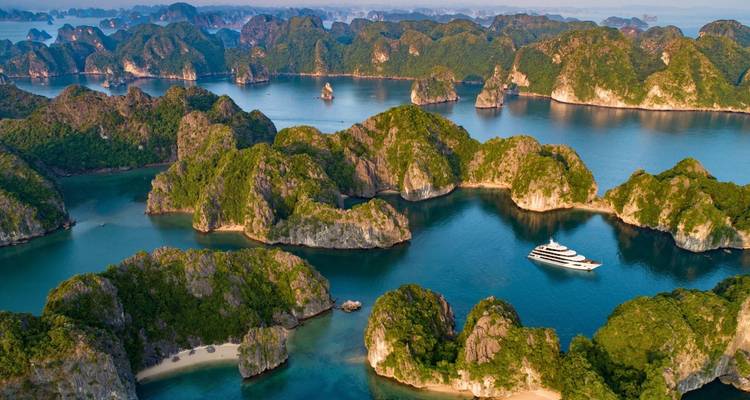 Luchtfoto van een cruise in Halong Bay omringd door eilanden.