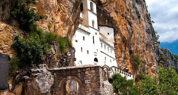 Weißes Kloster, das in eine Felswand hineingebaut wurde.