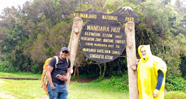Zwei Personen posieren vor einem Mandara Hut Schild.
