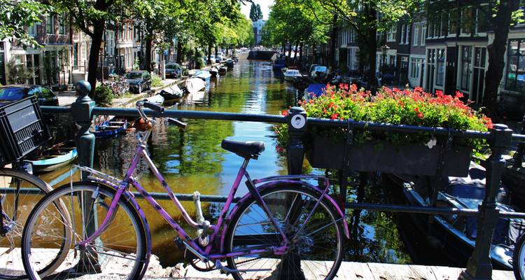 Vélo garé sur un pont au-dessus d'un canal.