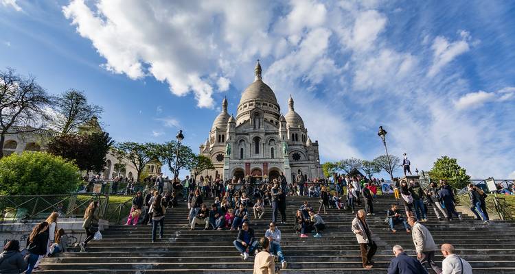 Basilique emblématique sur une colline avec de nombreux visiteurs.