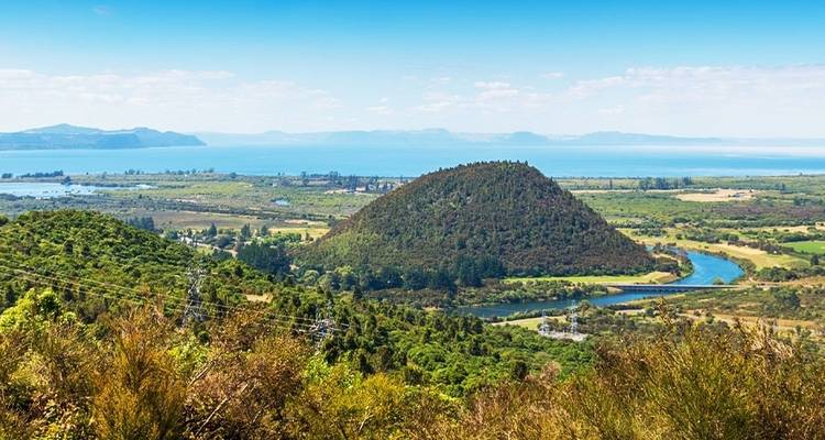 Colline avec des arbres et une rivière en arrière-plan.
