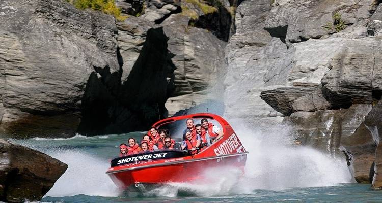 Groupe profitant d'une excursion en bateau à grande vitesse à travers une gorge rocheuse.