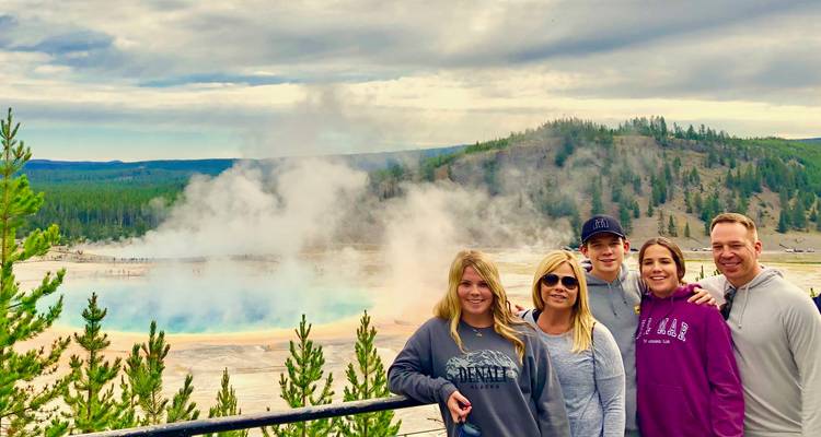 Familie poseert voor een dampend geothermisch gebied.