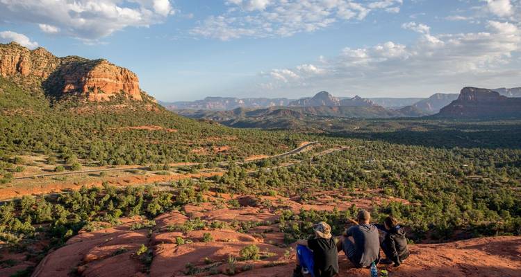 Hikers resting and enjoying a view of Sedona's red rock landscape.