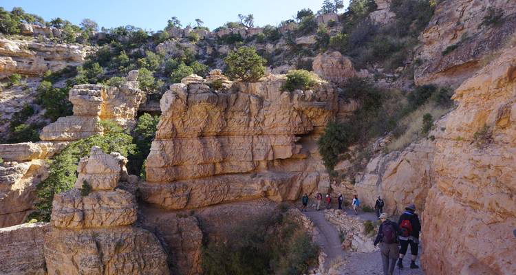 Hikers walking along a canyon trail.
