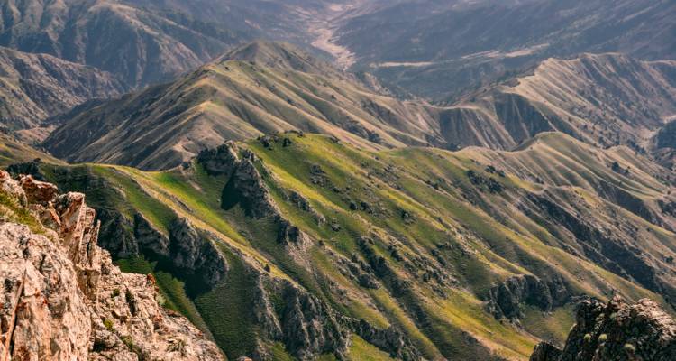 Collines vertes vallonnées et vallées au terrain accidenté.