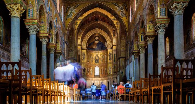 Intérieur d'une église richement décorée avec des personnes.