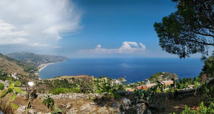 Vue panoramique de la côte de Taormina avec une végétation luxuriante.